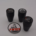 Four black HRB gear/shift knobs with logos and a circular HRB logo badge on a gray background.
