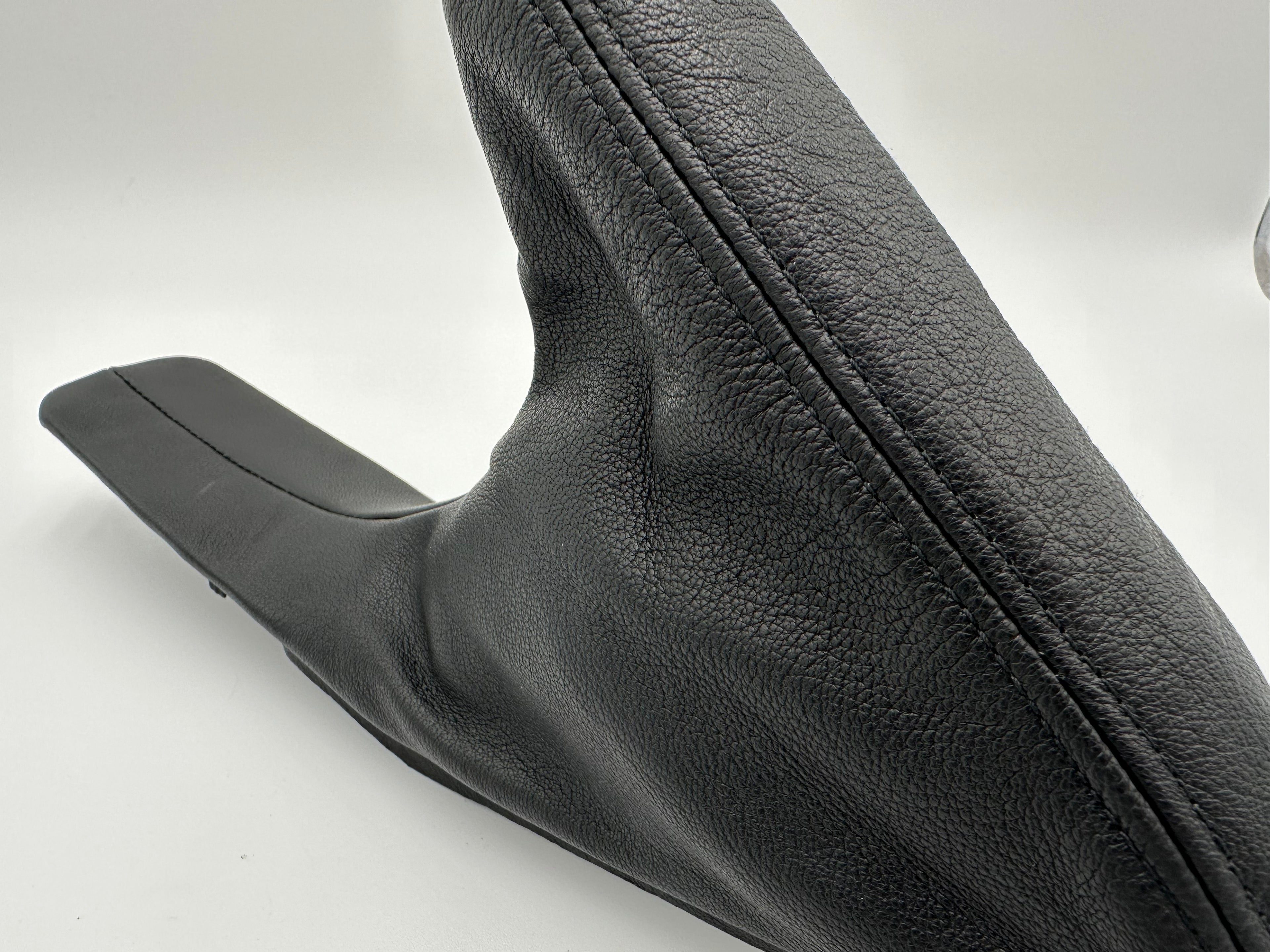 Close-up of a black leather BMW Z3 E-brake boot white background